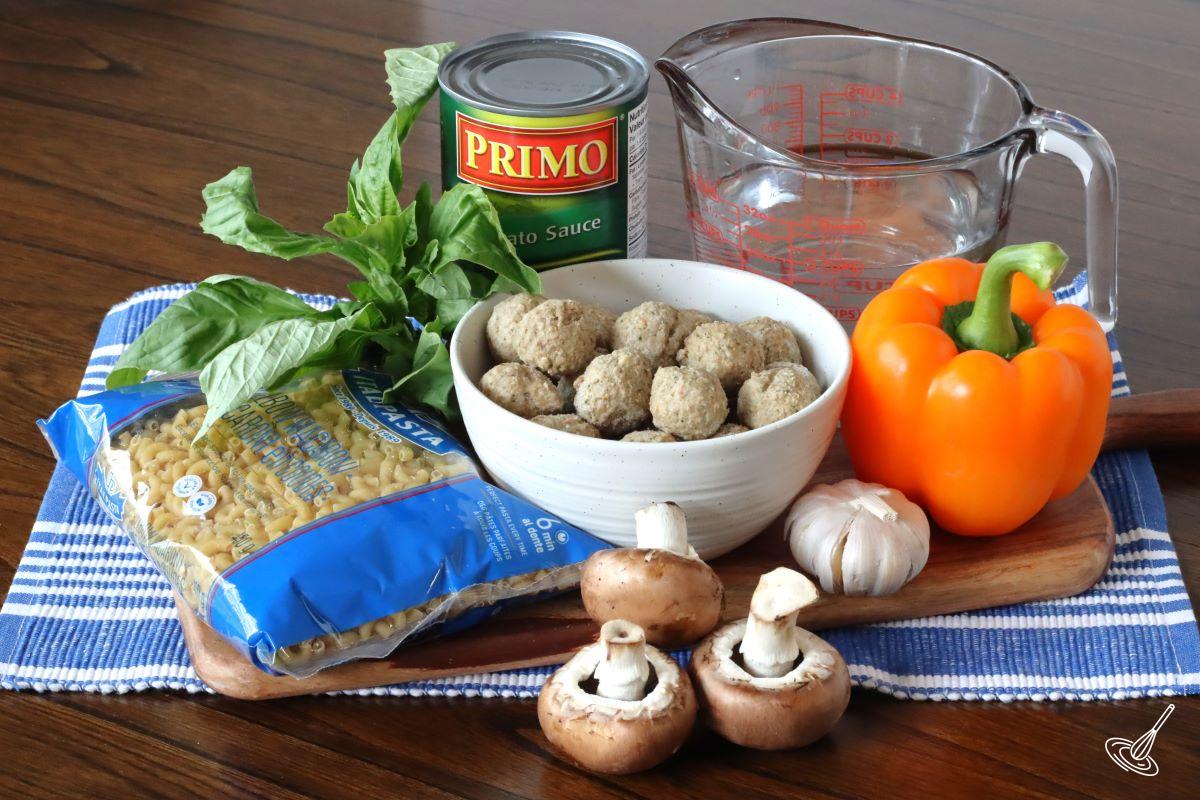 Ingredients grouped together, including pasta, meatballs, tomato sauce, mushrooms, and garlic. 