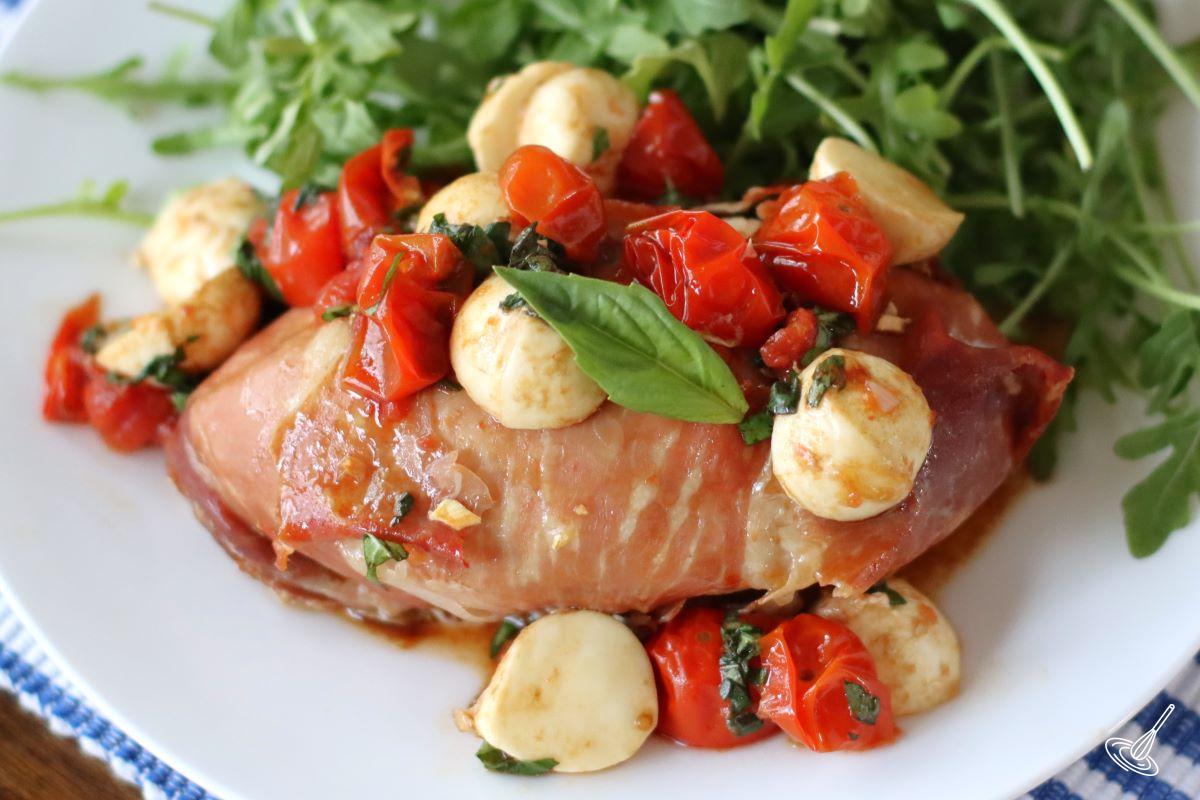 Caprese Chicken Saltimbocca on a plate with arugula salad.