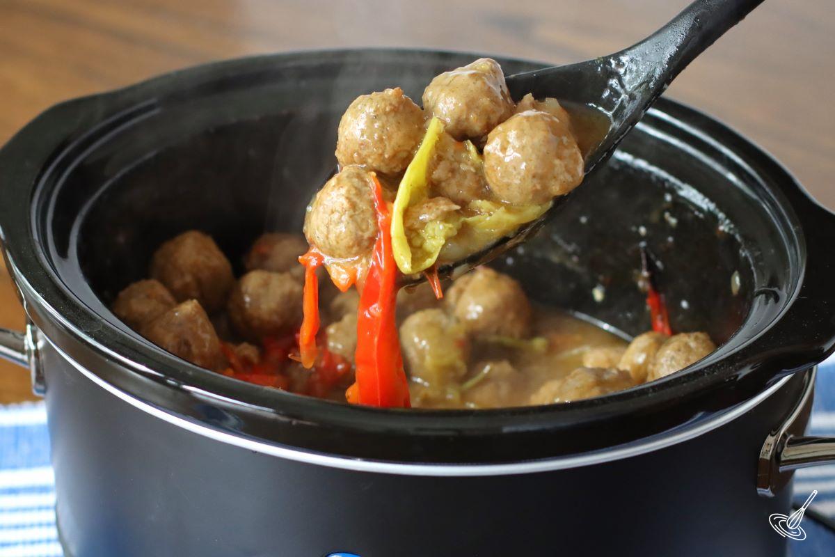 A serving spoon containing meatballs.