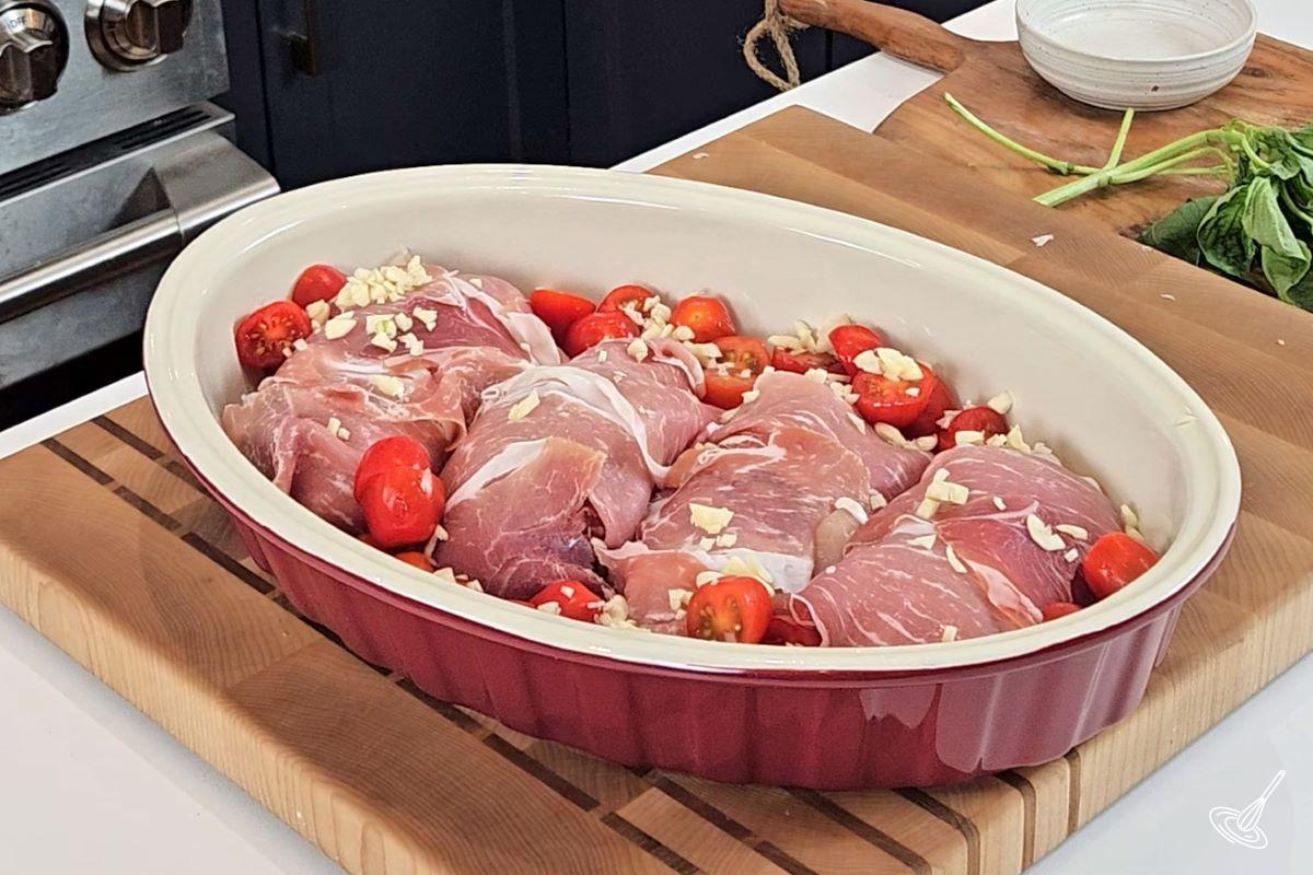 Caprese Chicken Saltimbocca with tomatoes in a baking dish. 