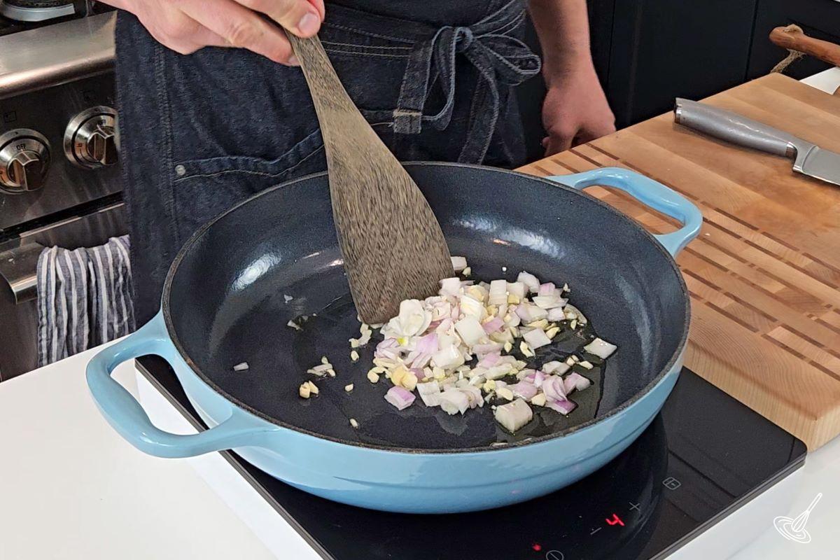 Chopped onion and garlic cooking in a large skillet.