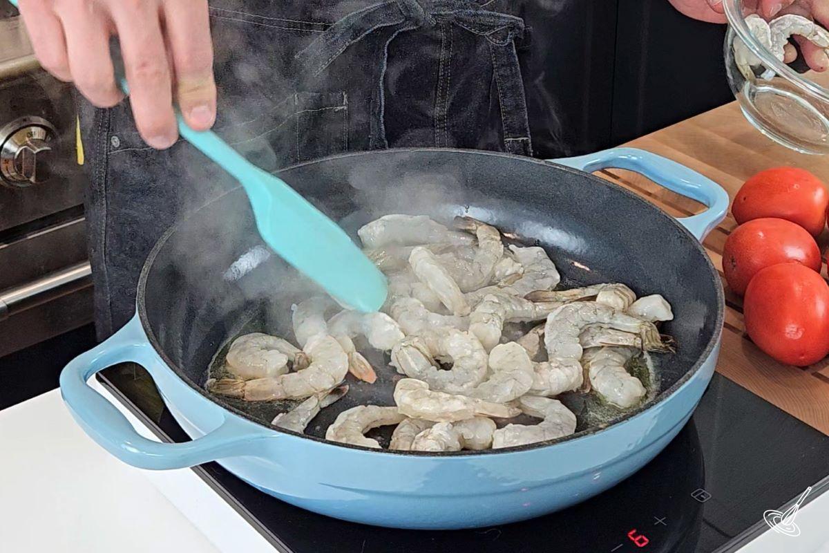 Shrimp cooking in a large skillet.