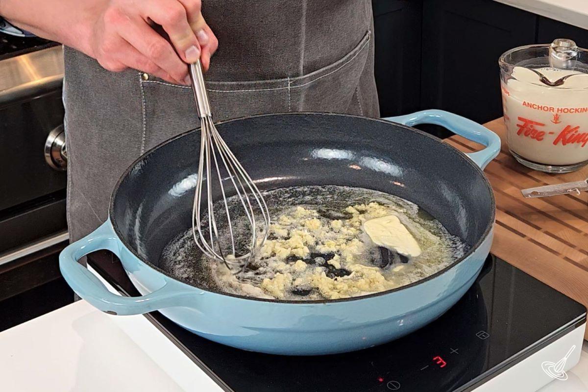 Someone melting butter in a large skillet.