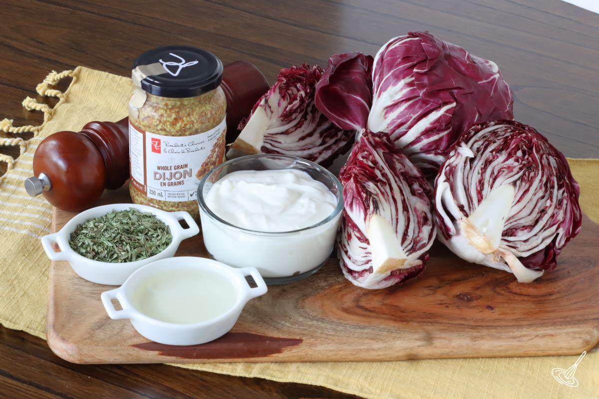 Ingredients on a wooden board, including radicchio, Greek yogurt, tarragon, and Dijon mustard.