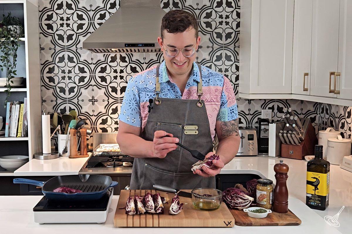 Someone brushing olive oil on a wedge of radicchio. 