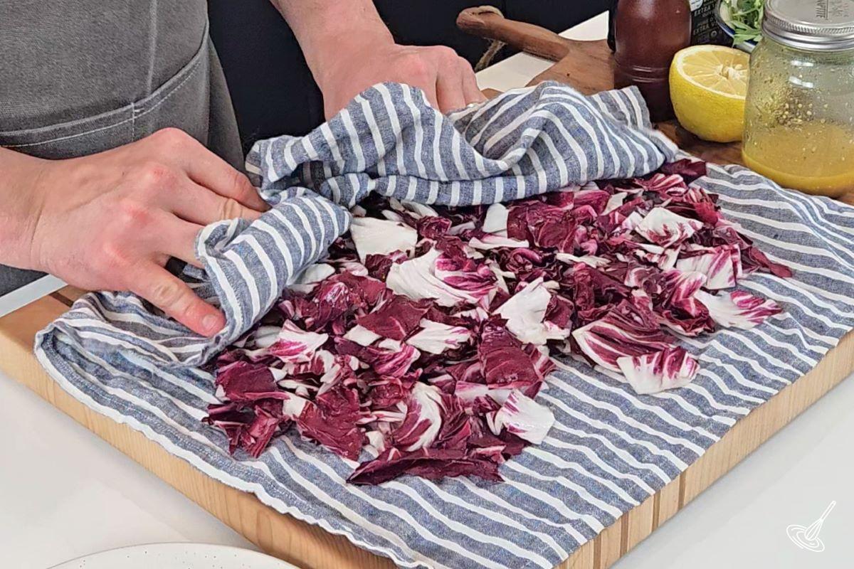 Someone patting down dry chopped radicchio.