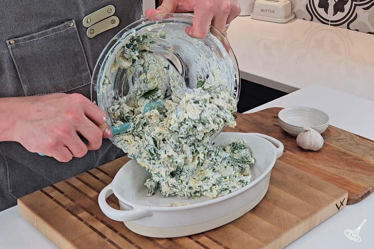 Someone pouring artichoke Spinach dip without mayo into a baking dish. 