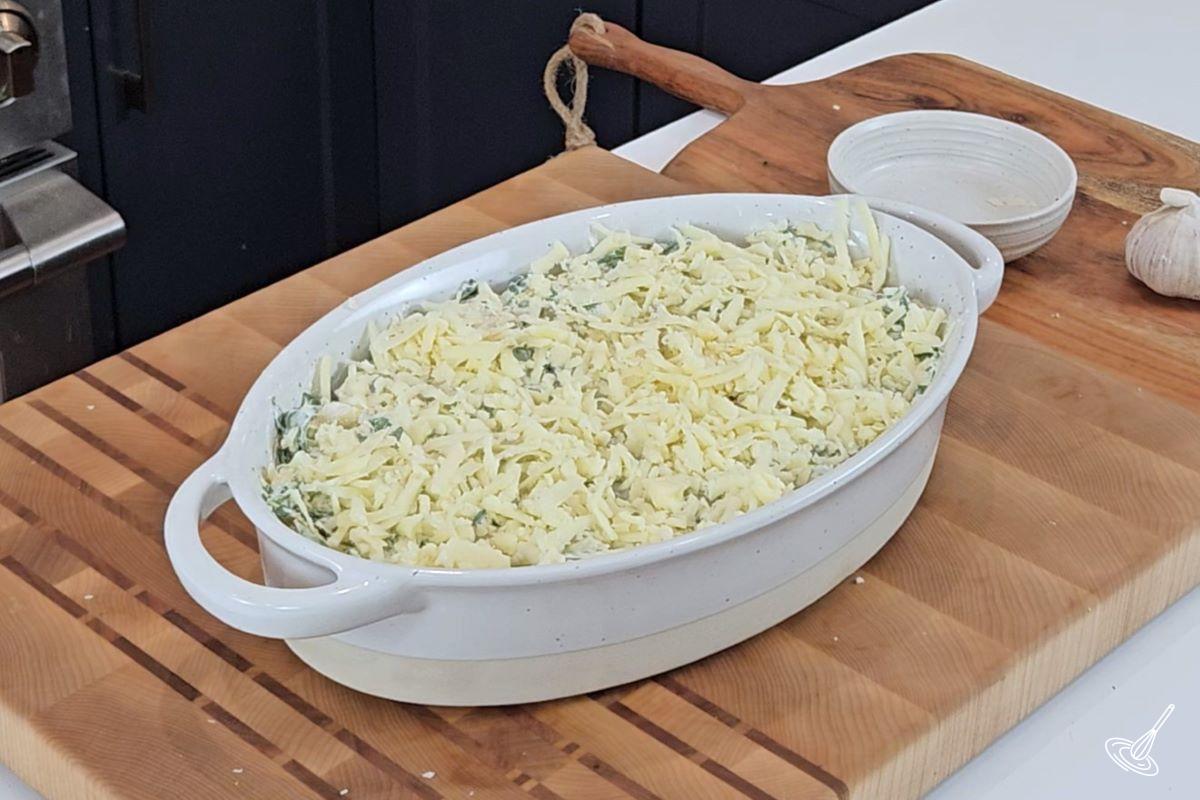A baking dish of artichoke spinach dip ready to be placed into the oven.