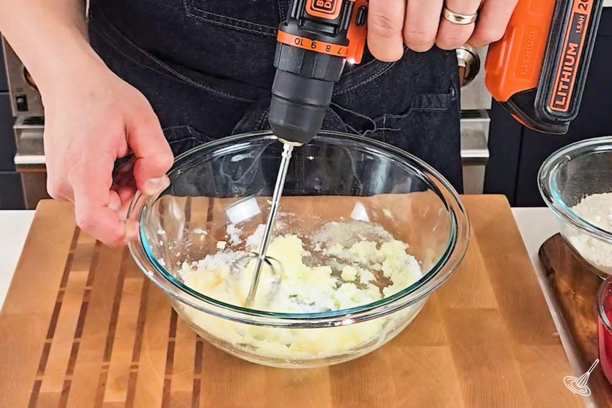Someone blending butter and sugar in a bowl.