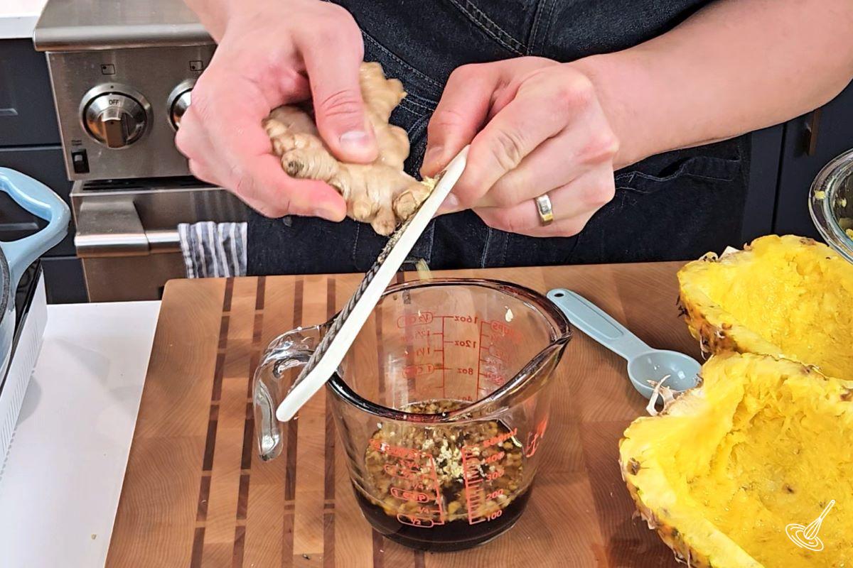 Someone grating a ginger root. 