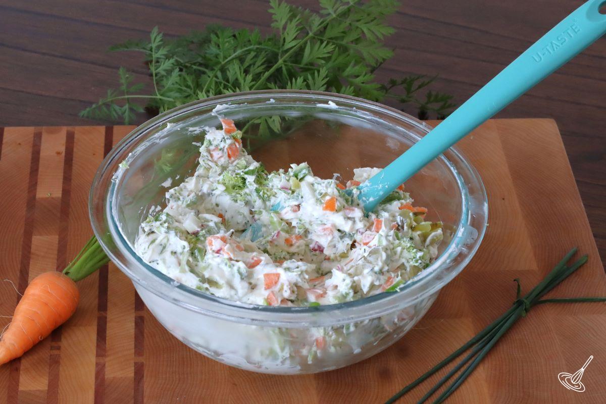 Garden vegetable cream cheese being mixed in a bowl. 