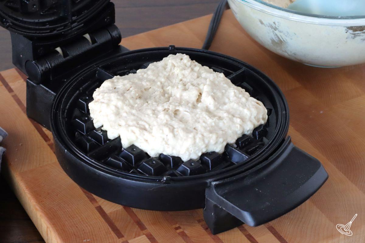 A scoop of waffle batter on a waffle iron. 
