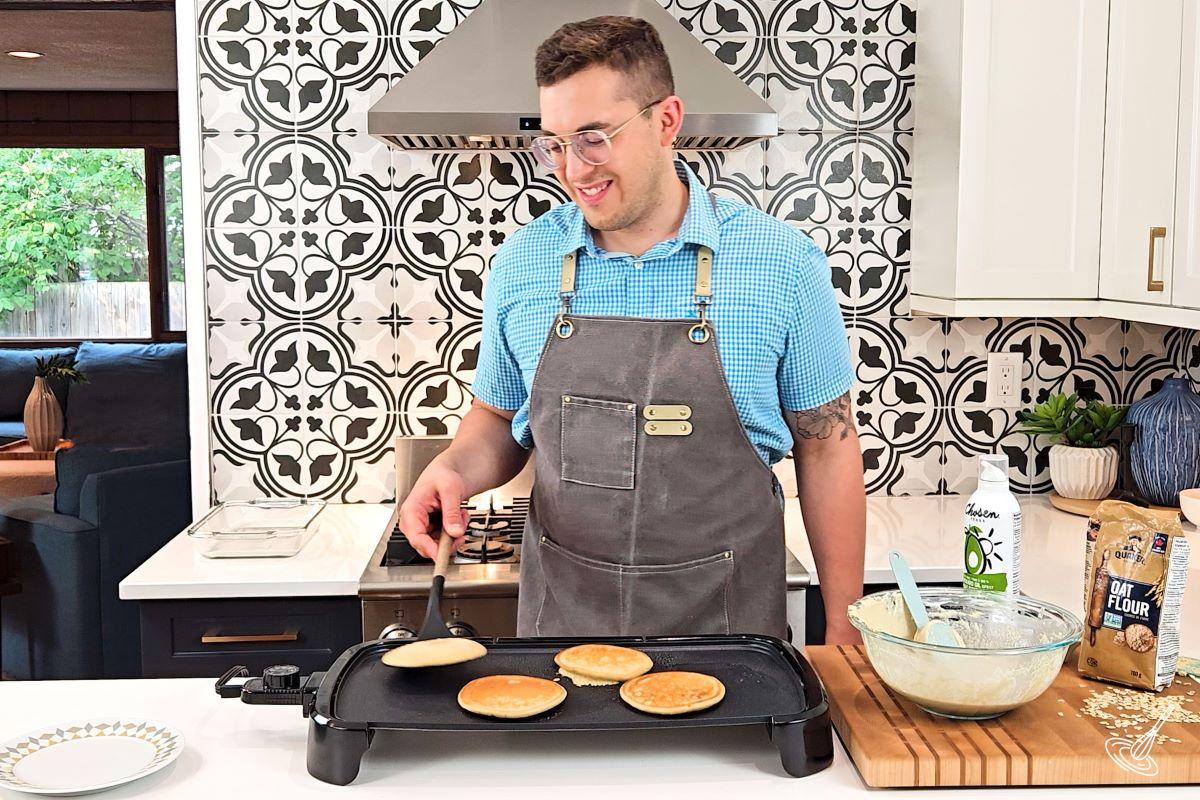 Someone flipping Greek Yogurt Oatmeal Pancakes on a griddle.
