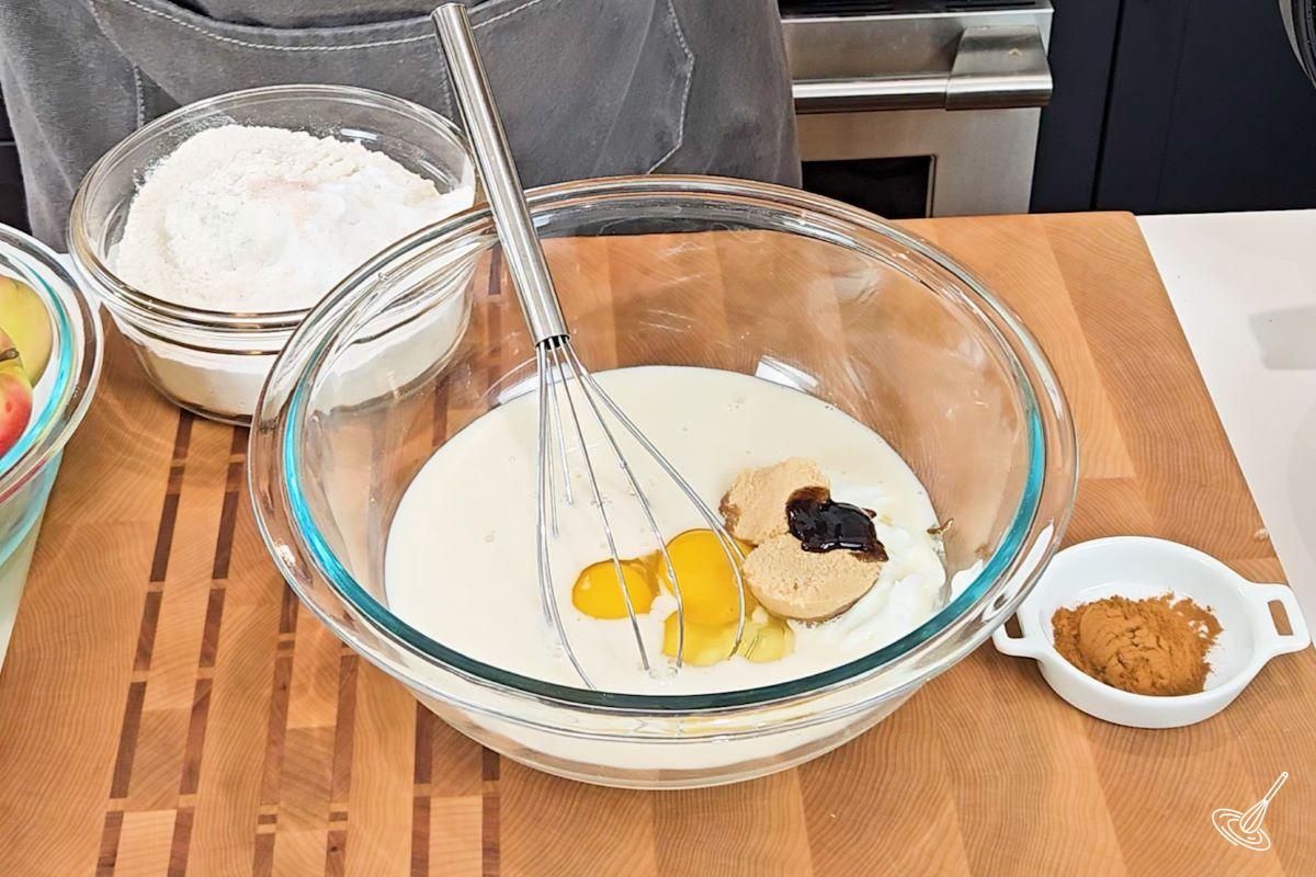 A large bowl containing eggs, milk, yogurt, and sugar. 