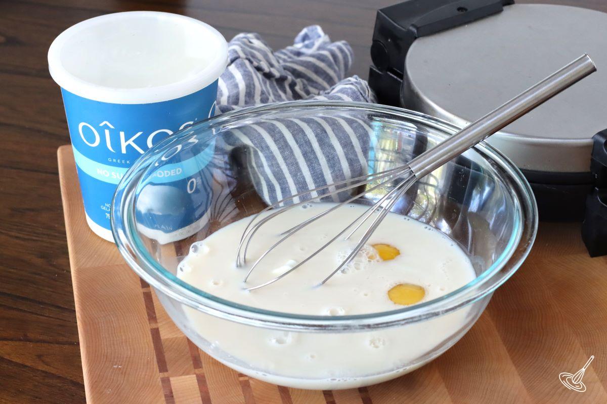 A large bowl containing milk and eggs. 