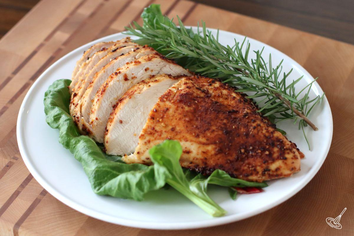 A sliced cooked turkey breast on a plate. 