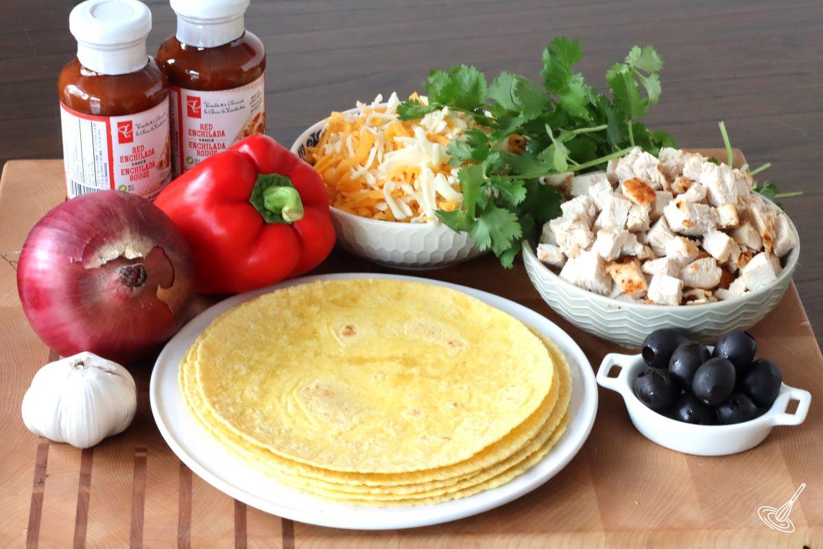 A plate of corn tortillas surrounded by dished of ingredients to make turkey enchiladas.