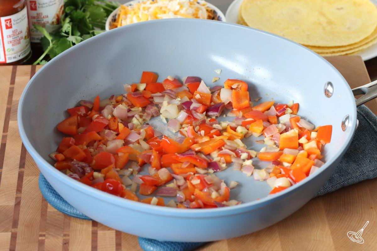 A frying pan with cooked bell peppers and onions. 
