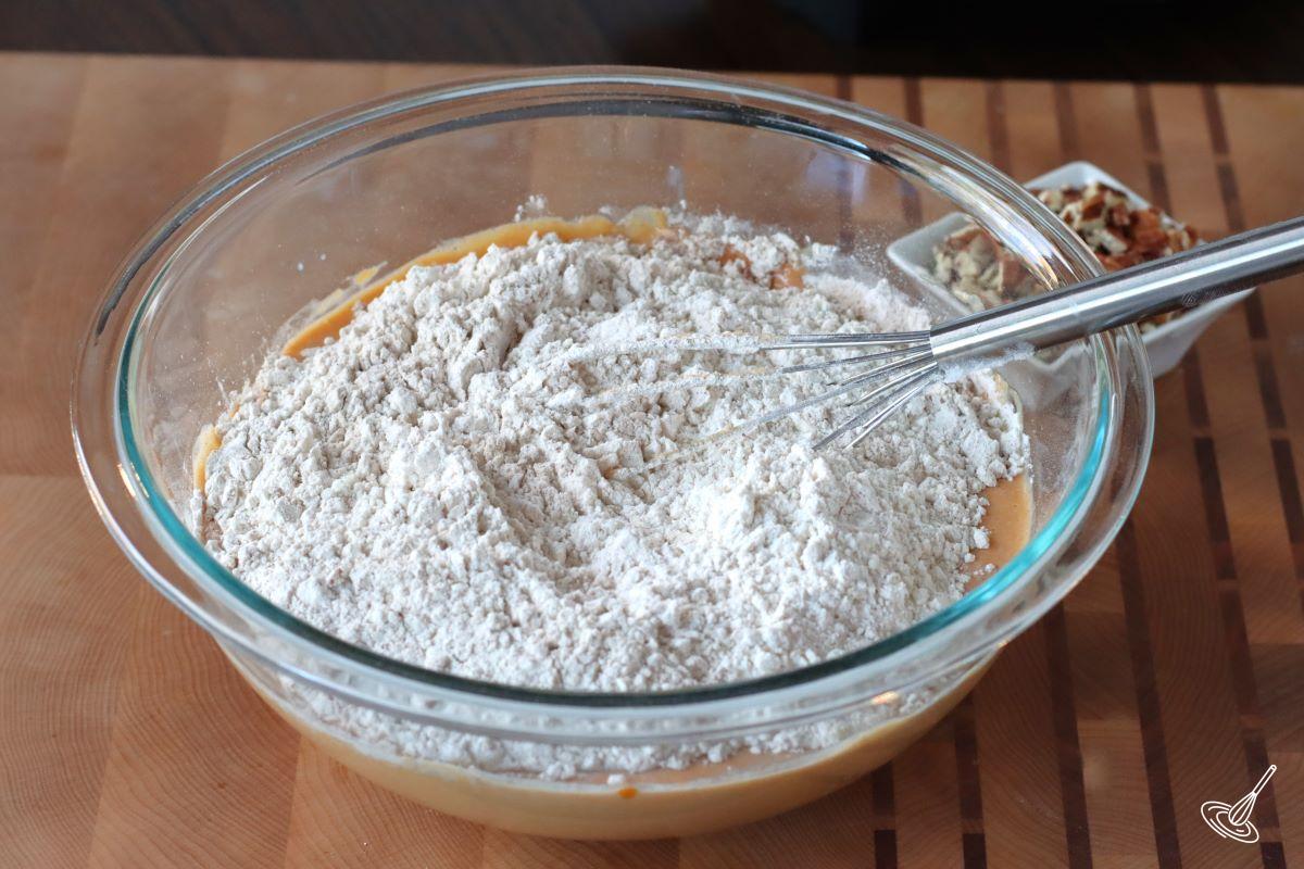 Dry ingredients in a large bowl with wet ingredients to make Pumpkin Pecan Waffles.