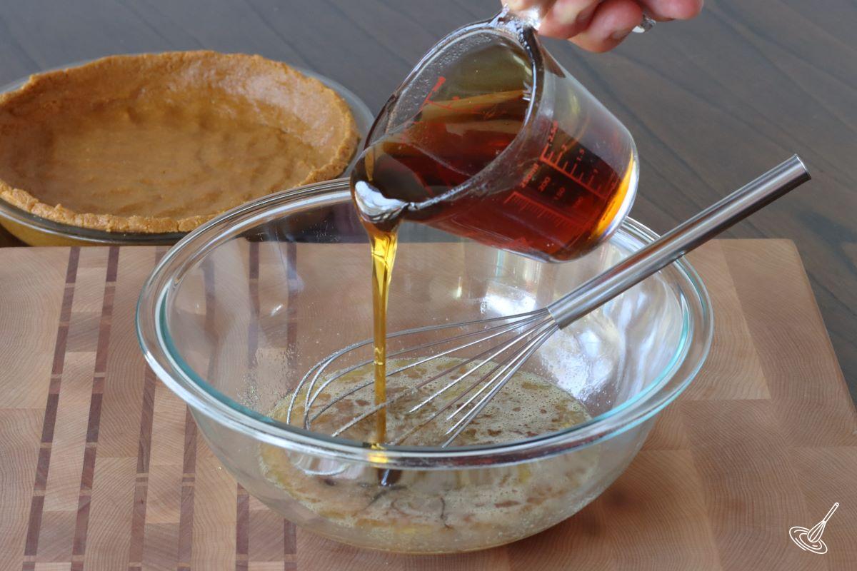 Someone pouring corn syrup in a large bowl.