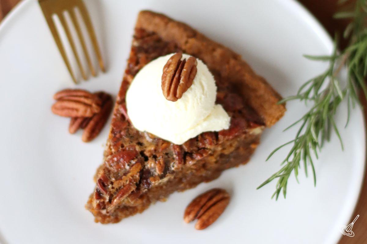 A slice of Pecan pie with graham cracker crust.
