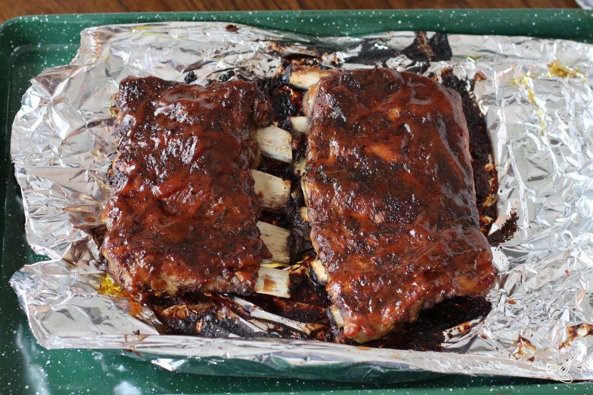 Cooked Dutch oven ribs on a baking tray.