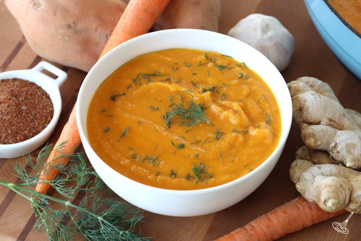 A bowl of Carrot Ginger and Sweet Potato Soup with fresh dill.