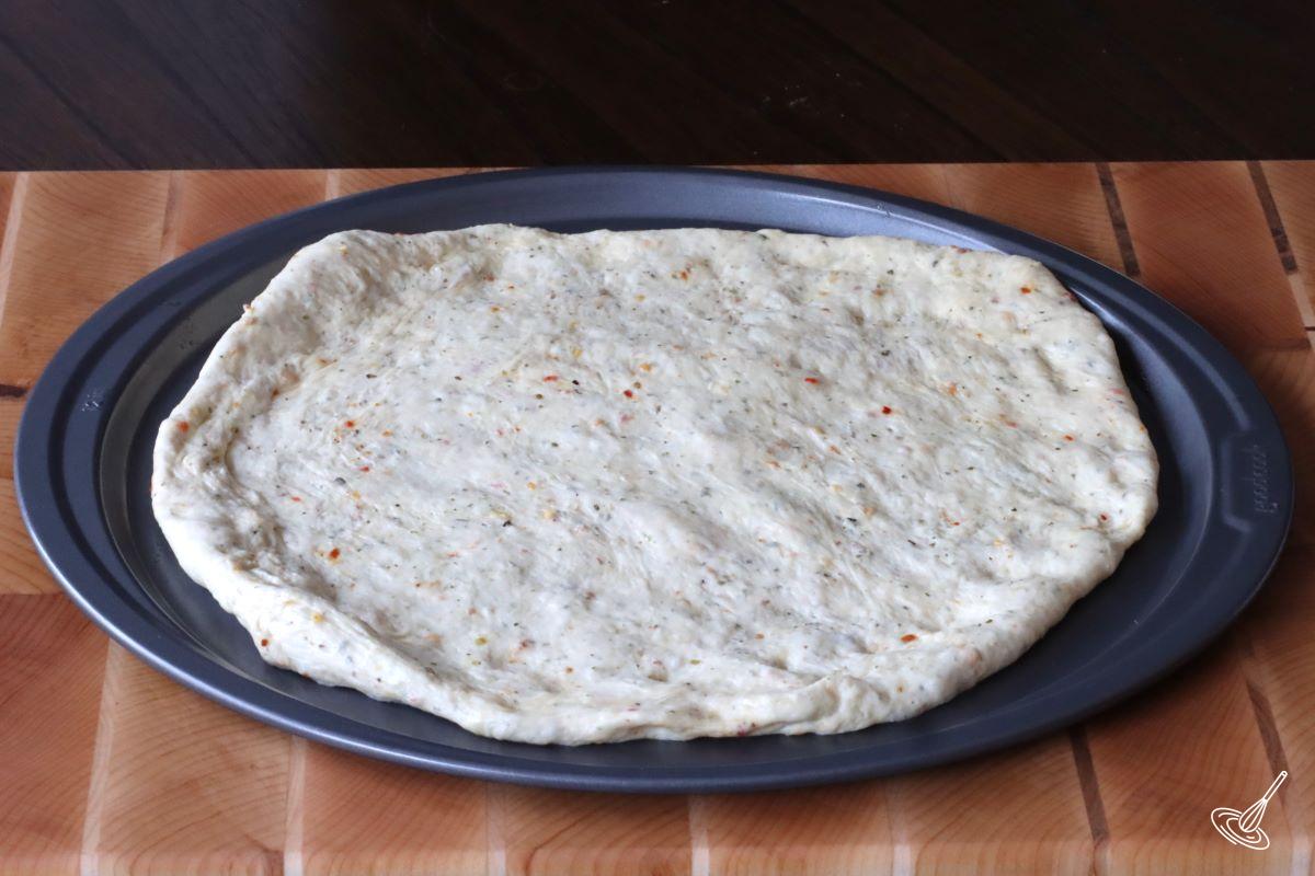 A pizza crust on a pan.