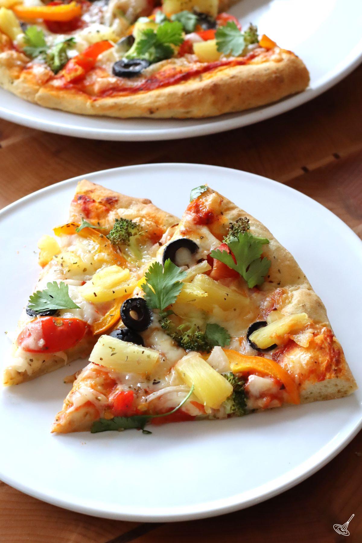 Slices of veggies pizza with pineapple on a plate.