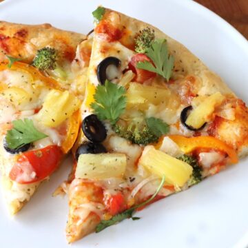 Slices of Veggies Pizza with Pineapple on a plate.