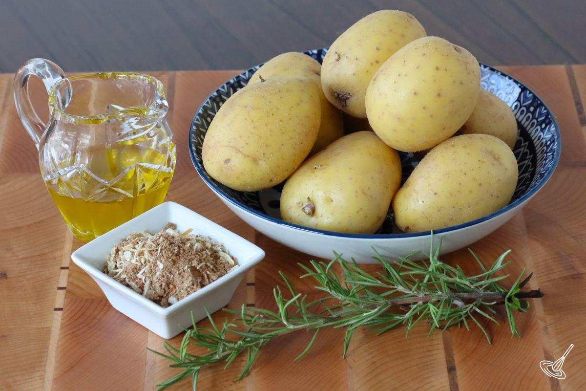 A large bowl of yellow potatoes with a side of olive oil and onion soup mix.