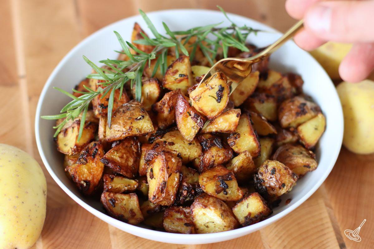 Someone taking roasted potatoes with onion soup mix with a fork. 