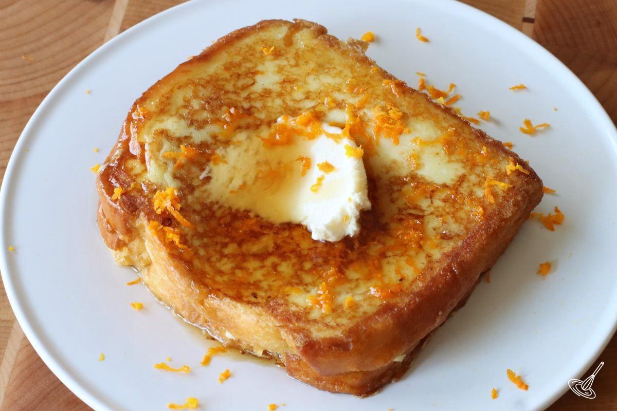 A Stuffed Brioche French Toast Orange Marmalade on a plate.