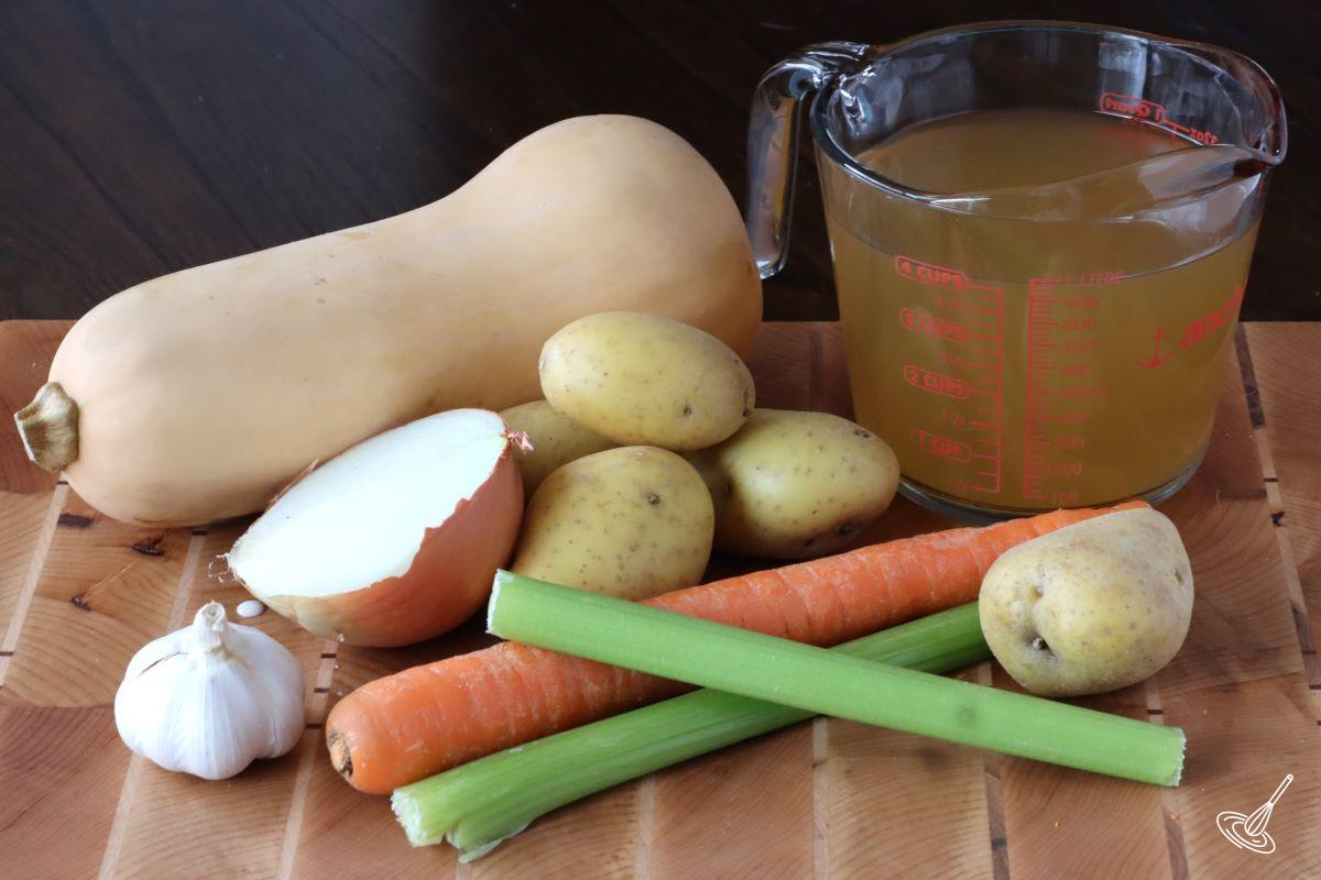 Vegetables and Chicken Broth on a cutting board.