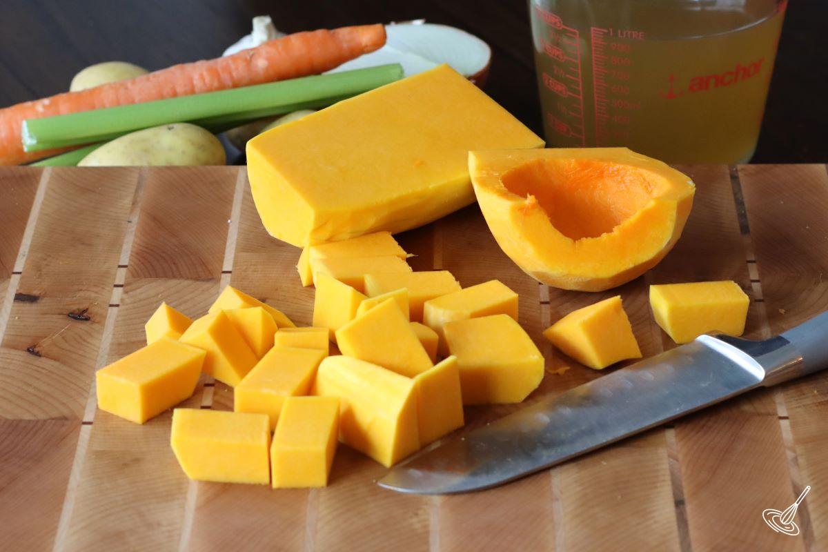 Someone cutting butternut squash into cubes.