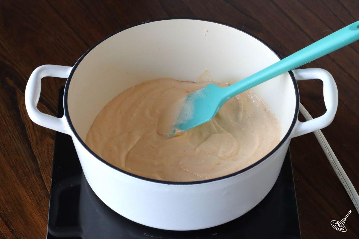 A large pot containing cheese sauce.