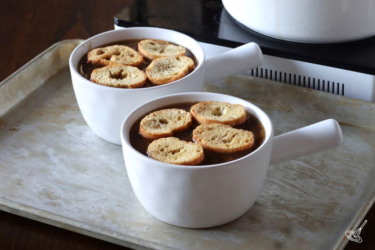 Two bowls French Onion Soup with Mushrooms with crostini on top.
