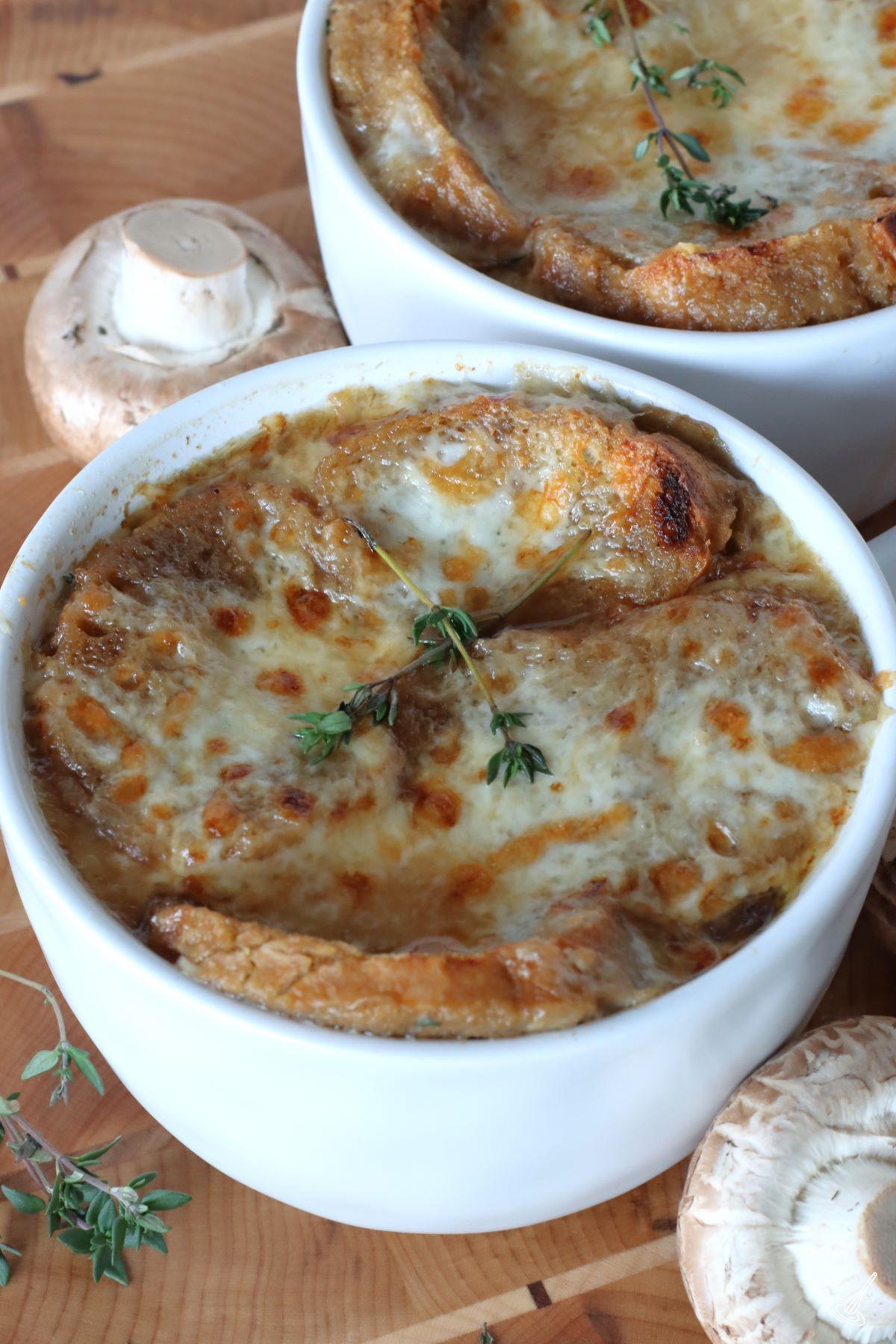 Two bowls of prepares French Onion Soup with Mushrooms.