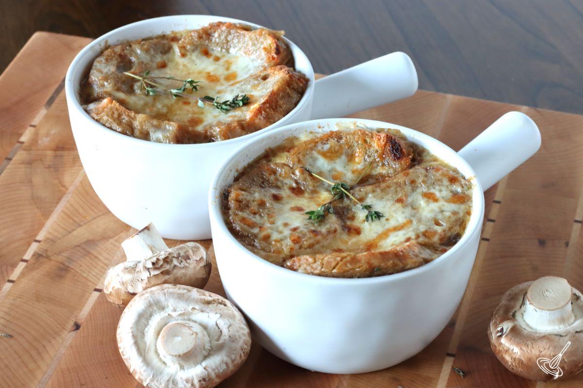 Two bowls of prepares French Onion Soup with Mushrooms.