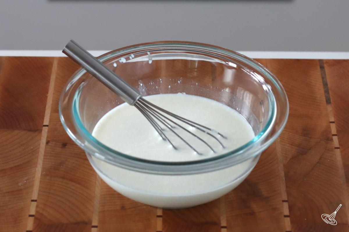 Milk in a bowl with a whisk. 