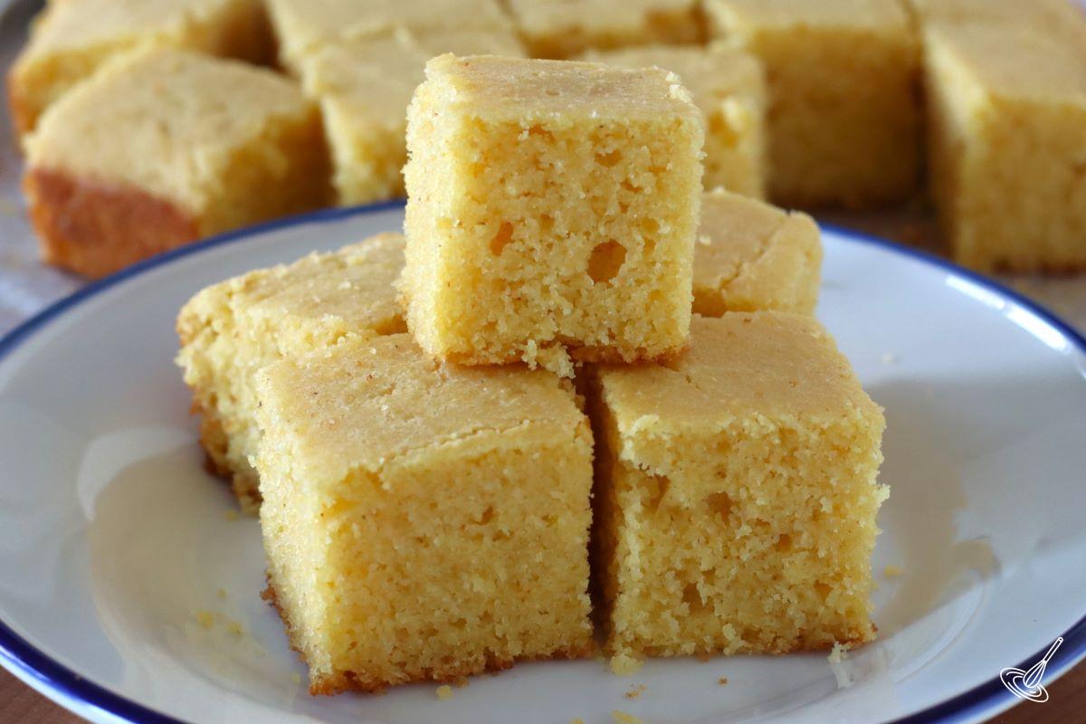 Pieces of cornbread without eggs stacked on a plate.