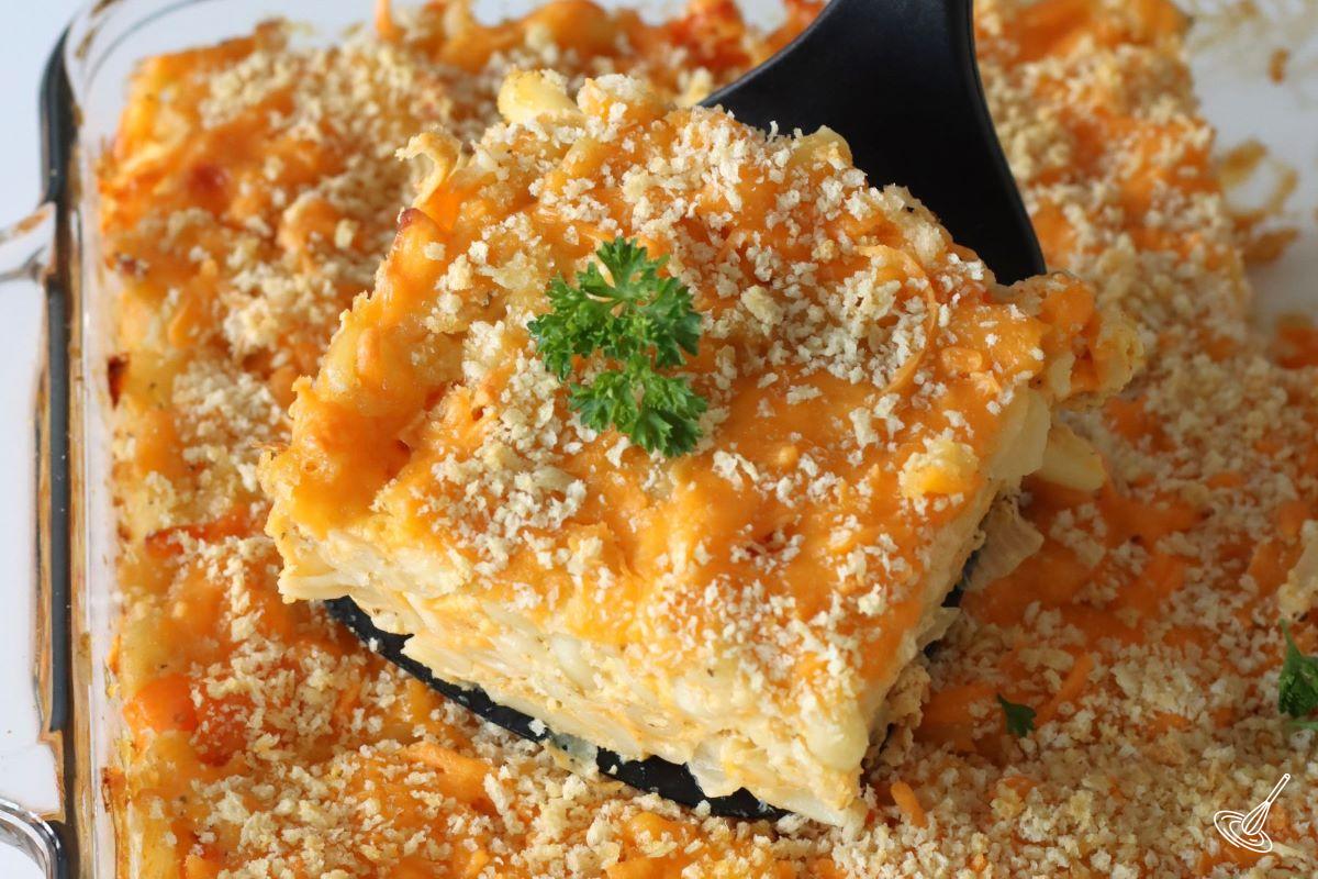 Someone serving a square of Bahamian Mac and Cheese.