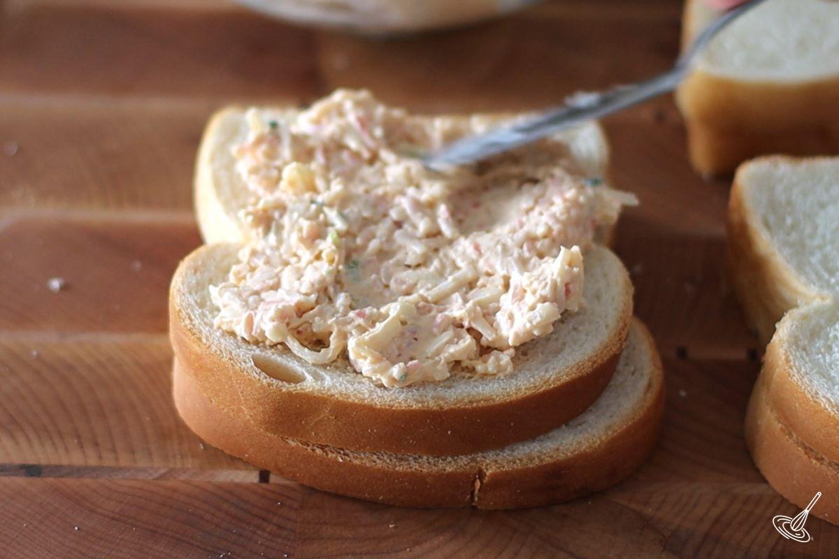 Someone spread crab Rangoon filling on a slice of sandwich bread.