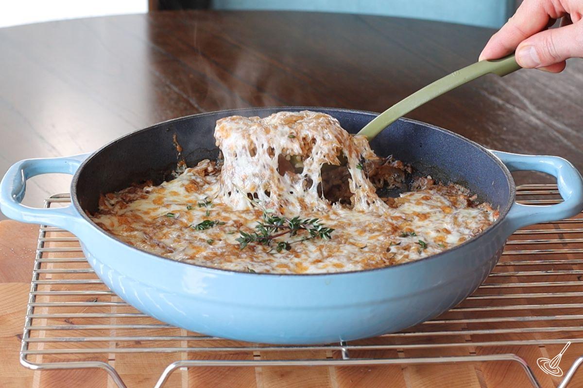 Someone scooping up a spoonful of French Onion Soup Rice. 