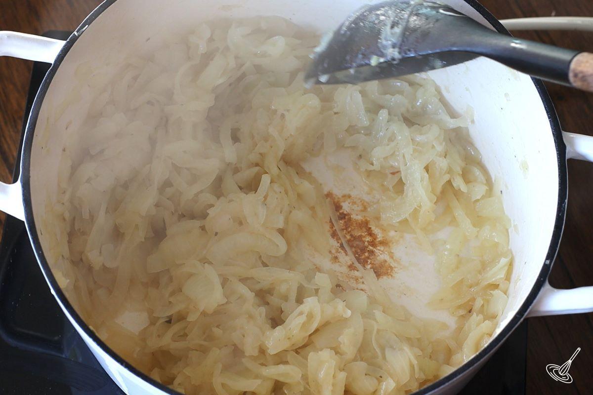 Onions being cooked in a Dutch oven. 