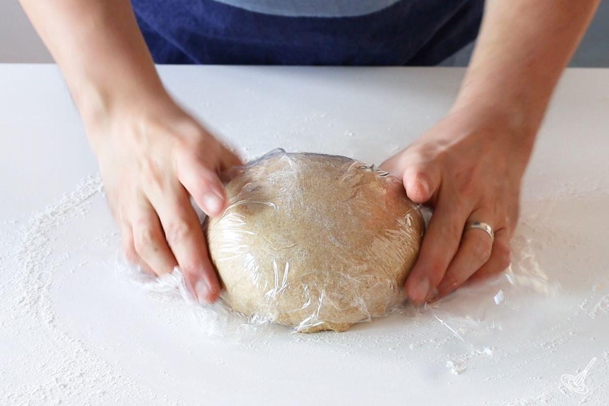 Einkorn Dinner Rolls dough covered in plastic wrap. 