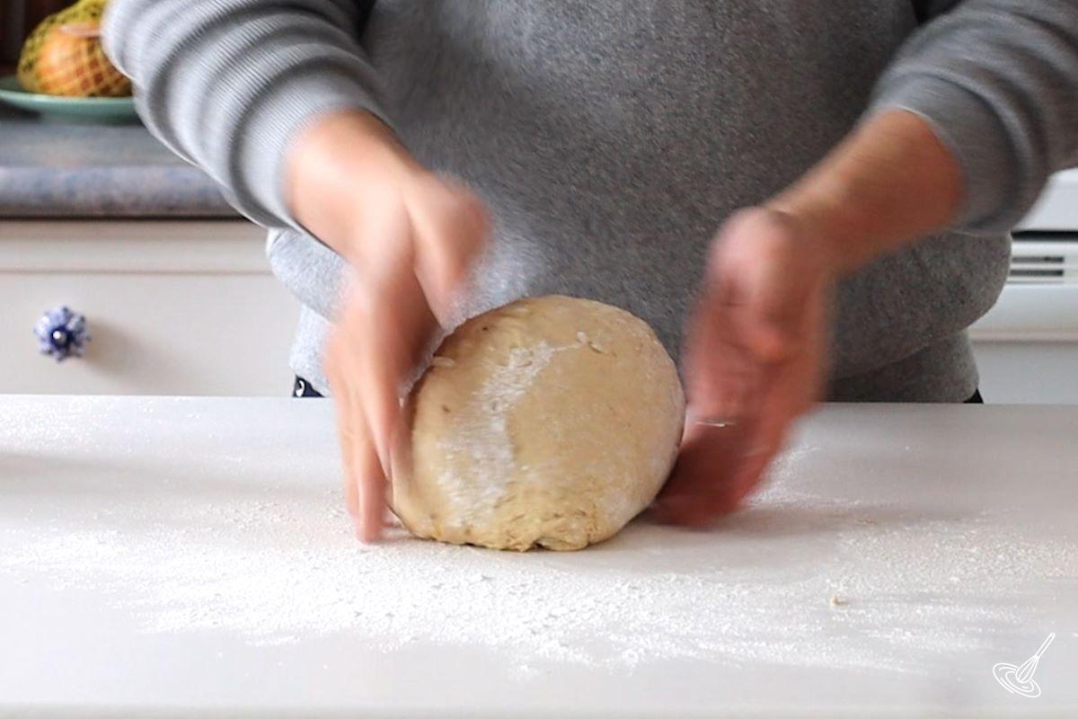 Someone shaping a ball of dough.