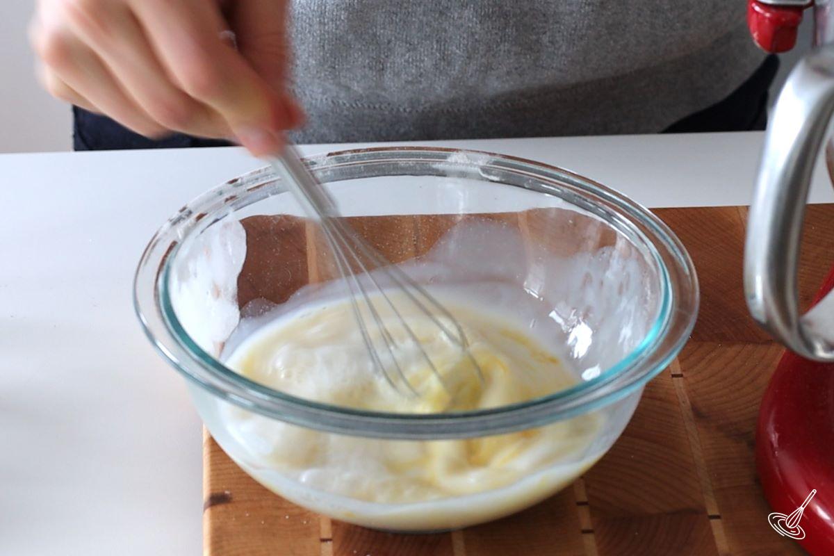 Someone whisking together egg and milk in a bowl.