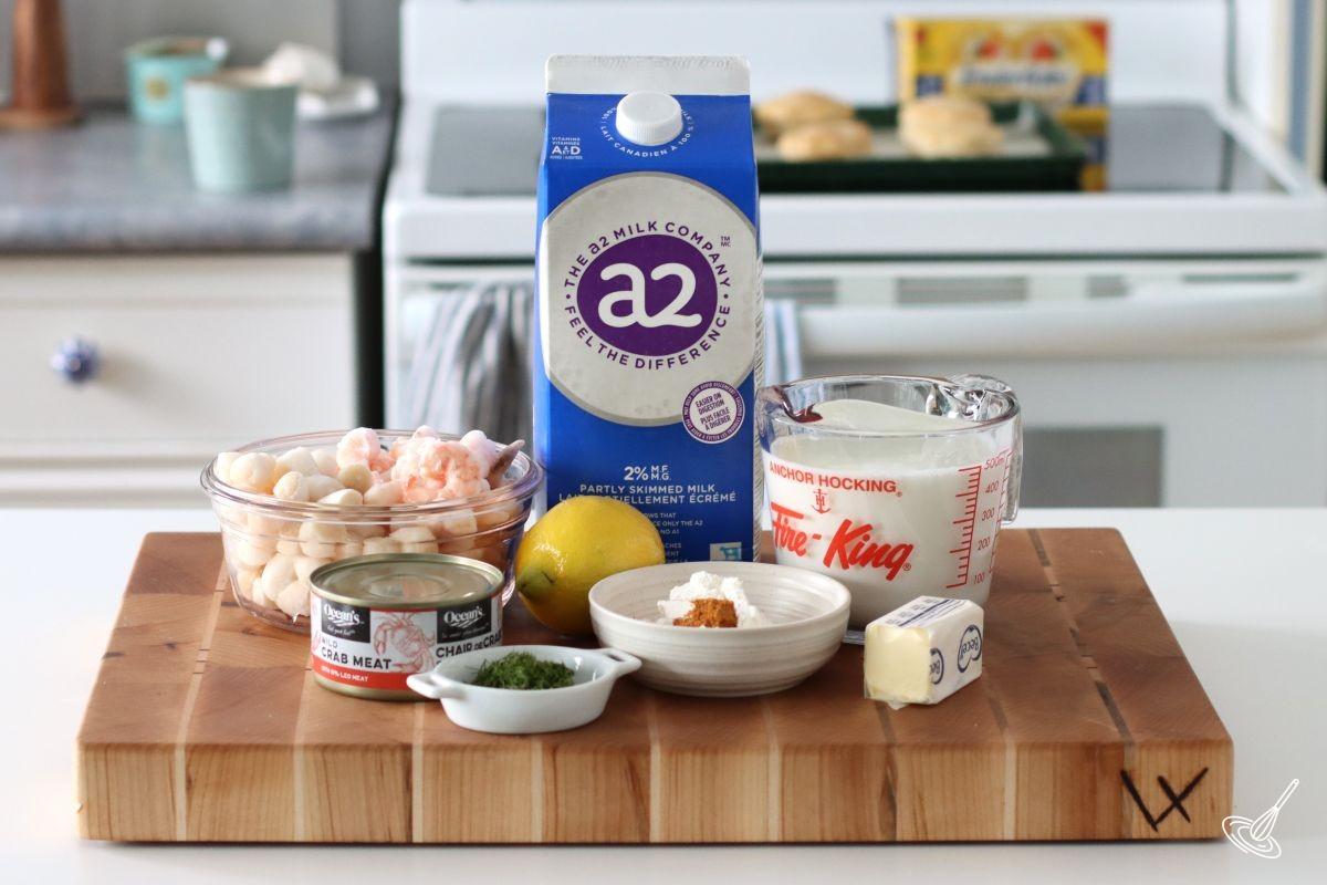 Ingredients on the counter including, milk, seafood, flours, and dill.
