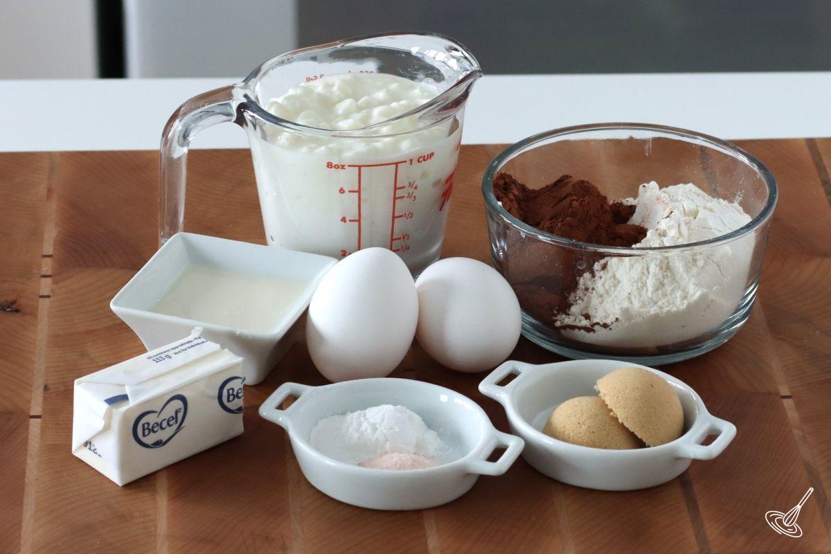 Ingredients to make Chocolate Cottage Cheese Waffles, including flour, cocoas powder, eggs, and cottage cheese.